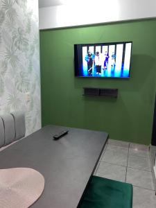 a living room with a television on a green wall at Green Space in Tarija