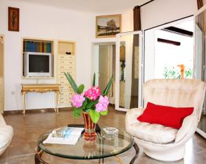 een woonkamer met een vaas met bloemen op een glazen tafel bij Hotel Residencia Miami in Torremolinos