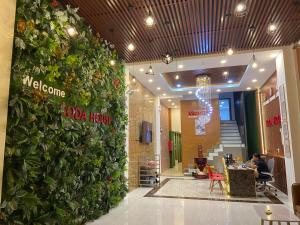 a lobby with a large green wall with plants at Soda House Cần Thơ in Can Tho