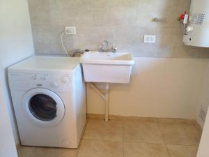 W łazience znajduje się pralka i umywalka. w obiekcie Alojamiento Amor Amarillo w mieście El Bolsón