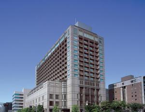 a tall glass building in front of some buildings at Hotel Okura Kyoto in Kyoto