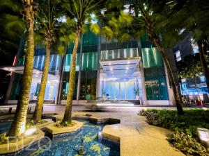 Soho suites klcc by Homestay في كوالالمبور: مبنى أمامه أشجار نخيل