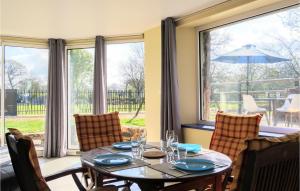 a dining room with a table and a large window at 3 Bedroom Amazing Home In La Hague in Vasteville