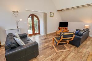 a living room with two leather couches and a television at Preacher's Rest in Grosmont