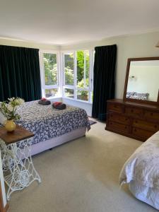 een slaapkamer met een bed, een spiegel en ramen bij Timber Trail Farmstay in Ongarue