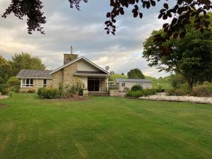 a house with a yard with a grass field at Timber Trail Farmstay in Ongarue