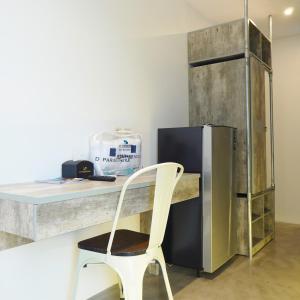 a white chair sitting next to a desk with a refrigerator at Dparagon Menteng Jakarta in Jakarta