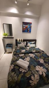 um quarto com uma cama grande e uma colcha floral em D'MANGO COTTAGE MELAKA HOMESTAY BANDAR HILIR DAN KLEBANG em Malaca