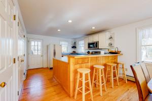 a kitchen with a wooden counter and stools in it at White Pearl in Oak Bluffs