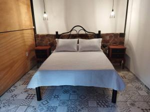 a bed in a room with two nightstands and two tables at Apartamento Dos hermanas in Colonia Estrella