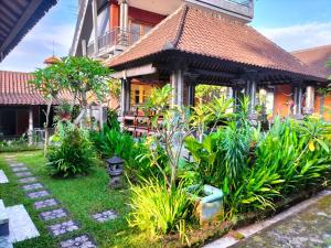 a garden in front of a house with plants at Ojek's Homestay in Ubud