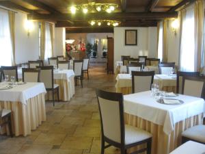 una sala da pranzo con tavoli e sedie bianchi di Albergo Giardino a Sannazzaro deʼ Burgondi