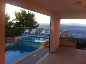 a swimming pool with a view of the ocean at Apartments Mlad - with pool in Rogač