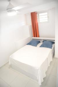 a bedroom with a white bed and a window at Suite jacuzzi et vue panoramique - BED AND COFFEE AIRPORT in Ducos