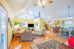 a living room with yellow walls and a large window at Tree Top Cabin in Sylva