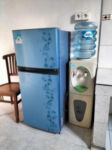 un frigorifero blu accanto a una lavatrice con una pila d'acqua di Leket house ad Ubud