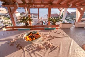 a bowl of fruit on a table with a view of the ocean at Apartments Drago - with sea view in Klek