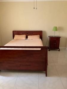 a bedroom with a wooden bed and a night stand at 12 Fairway Avenue in Kingston