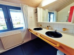 a bathroom with two sinks and a mirror at BodenSEE Apartments Kressbronn "HAUS AM SEEPARK" in Kressbronn am Bodensee