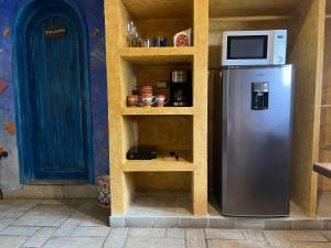 a refrigerator with a microwave on top of it at Hacienda Boutique B&B and Spa Solo Adultos in Cozumel