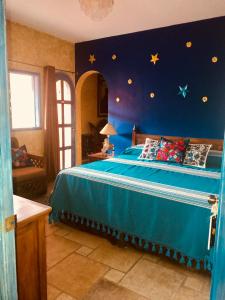 een slaapkamer met een blauw bed met sterren aan de muur bij Hacienda Boutique B&B and Spa Solo Adultos in Cozumel