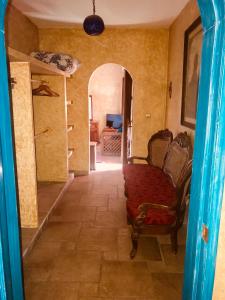 einen Flur mit einem Zimmer mit einem Bett und einem Stuhl in der Unterkunft Hacienda Boutique B&B and Spa Solo Adultos in Cozumel