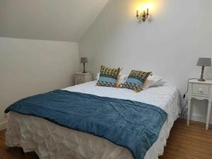 Schlafzimmer mit einem Bett mit blauer Bettwäsche und Kissen in der Unterkunft Gîte Mareuil-sur-Arnon, 4 pièces, 6 personnes - FR-1-586-22 in Mareuil-sur-Arnon