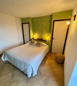een slaapkamer met een wit bed en groene muren bij Hotel Le Saint Jean in Ersa