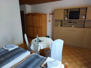 a room with a table and a bed and a tv at Hotel & Pension Haus Dewenter in Lichtenau