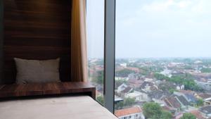sypialnia z dużym oknem z widokiem na miasto w obiekcie Lavenderbnb Room 2 at Uttara the Icon Apartment w mieście Yogyakarta