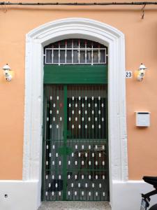 a green door with white keys on a building at Casa Bella - Ortigia & Neapolis in Syracuse