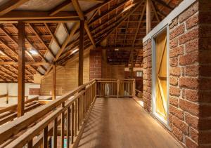 uma sala vazia com uma parede de tijolos e uma passarela de madeira em SaffronStays Crescent Bay, Palshet em Chiplun mais 14 fotografias