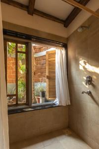 baño con ducha con ventana y ventana en SaffronStays Crescent Bay, Palshet, en Chiplun