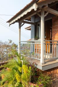 porche de una casa con balcón en SaffronStays Crescent Bay, Palshet, en Chiplun