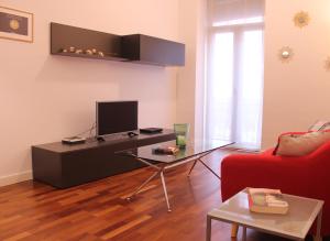 een woonkamer met een televisie en een rode bank bij Modern Apartment - Alicante in Alicante