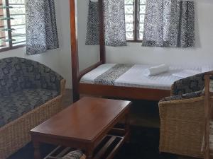 um pequeno quarto com uma cama, uma mesa e cadeiras em New Muna House. em Ukunda mais 29 fotografias