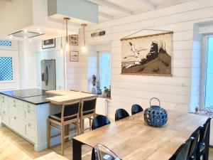 uma cozinha e sala de jantar com uma mesa de madeira e cadeiras em BEACH HOUSE VILLA LES BLEUETS em Le Pouldu