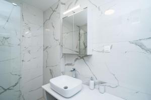 a white bathroom with a sink and a mirror at Apartment NAVA - new and spacious gem - FREE PARKING in Dubrovnik +37 photos