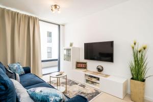 a living room with a blue couch and a tv at Apartment NAVA - new and spacious gem - FREE PARKING in Dubrovnik