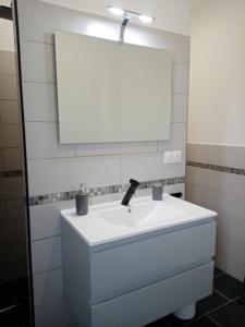 a bathroom with a white sink and a mirror at L escapade in Rabastens