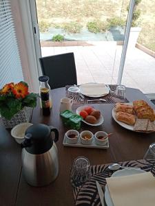 a table with breakfast food on a table with a window at L escapade in Rabastens