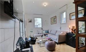 sala de estar con sofá y TV en BEACH HOUSE VILLA LES BLEUETS en Le Pouldu