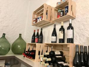 un mucchio di bottiglie di vino sedute su uno scaffale di Hotel L'Escale ad Aigues-Mortes