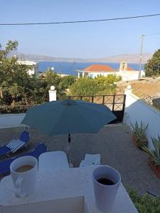 - une table avec un parasol bleu et des chaises dans l'établissement VILLA ANNA, à Ravdhoúkha