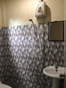 een badkamer met een douche en een wastafel bij AMK traveller's hub in Maite