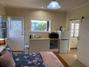 ein Schlafzimmer mit einem Bett und eine Küche mit einem Kühlschrank in der Unterkunft Hideaway on Hume #3 in Boonah