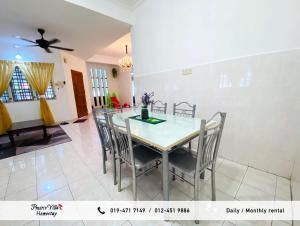 a dining room with a table and chairs at Prairie Villa Homestay in Lumut +27 photos