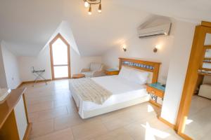 a bedroom with a white bed and a window at Datca Kilic Hotel in Datca