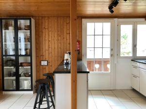 a kitchen with wooden walls and a counter with stools at Chalet Pironnet with BEST Views, Charm and Comfort! in Lauterbrunnen