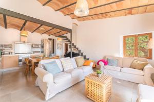 sala de estar con 2 sofás blancos y cocina en Els Abats, en Fornalutx